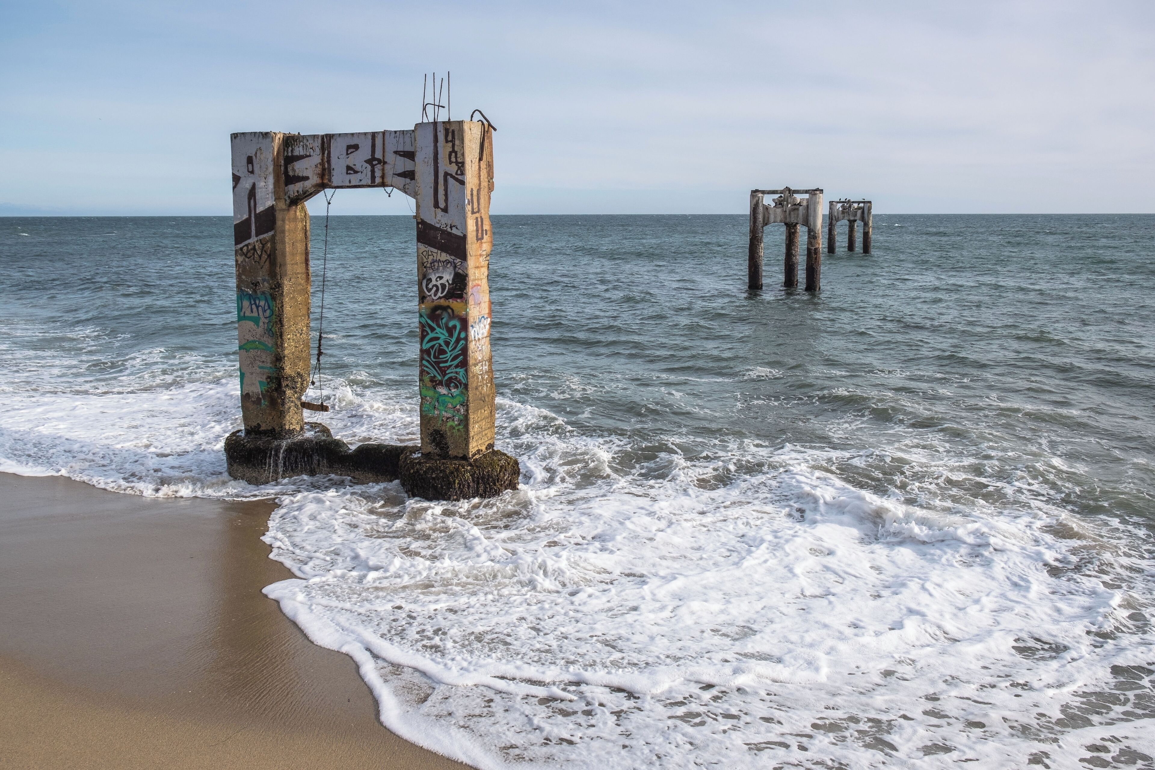 This unique spot is the site of old concrete pier ruins in the quaint coastal village of Davenport, which now is just a set of concrete pylons that used to hold it up. Davenport is located just North of Santa Cruz, on the northern edge of the famed Monterey Bay Peninsula.  The pier is a spot known to attract photographers from all over wishing to capture the beautiful abandoned pier. 

The only way down to the beach is down a steep cliff.  At the top of the climb down this is a climbing rope jimmy rigged to a metal fence pole which helped with getting up and down. The trail down the cliff needed a little bit of climbing experience but it wasn't as daunting as it seems from above.

#likealocal