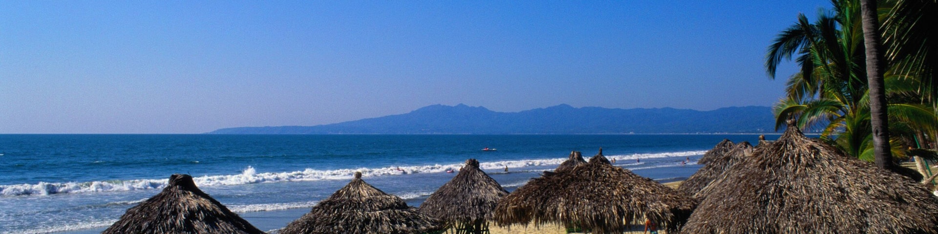 Mexico, Puerto Vallarta, grass umbrellas on beach