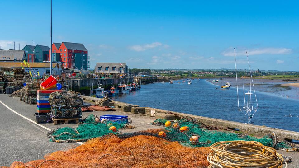 View of fishing nets on quayside and River Coquet at Amble, Morpeth, Northumberland