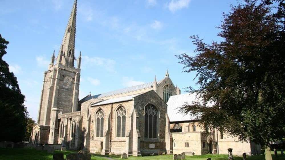 A church with a tall spire and large windows.