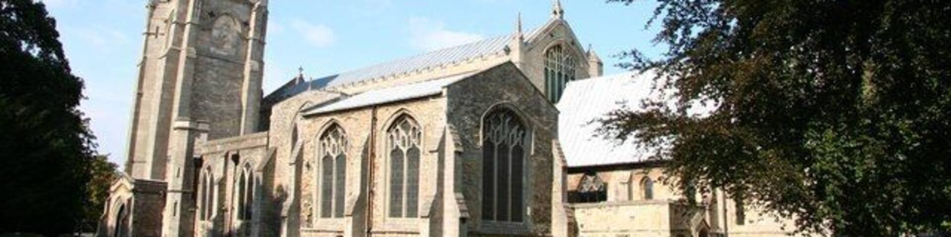 A church with a tall spire and large windows.