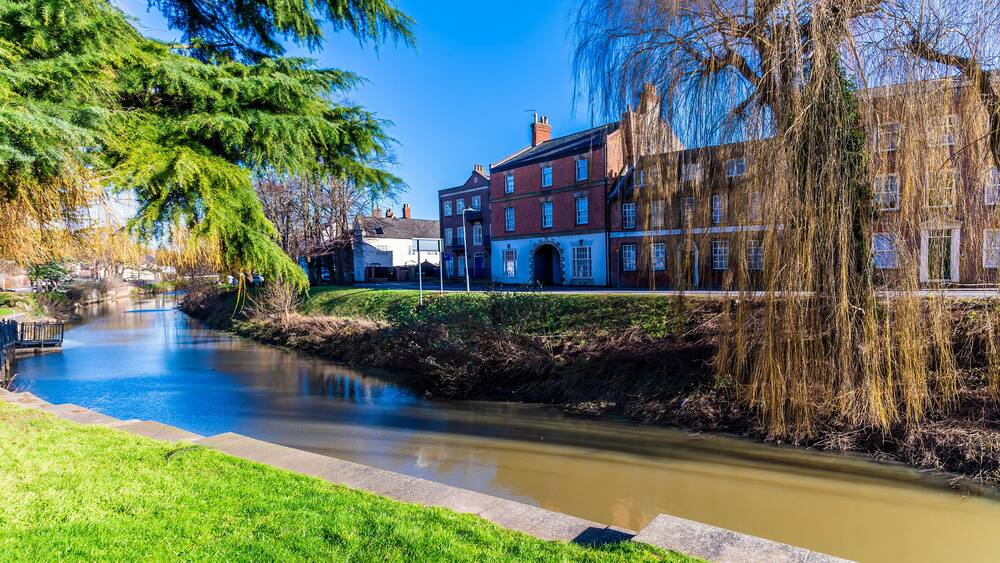 A river with buildings on one side and trees on the other.