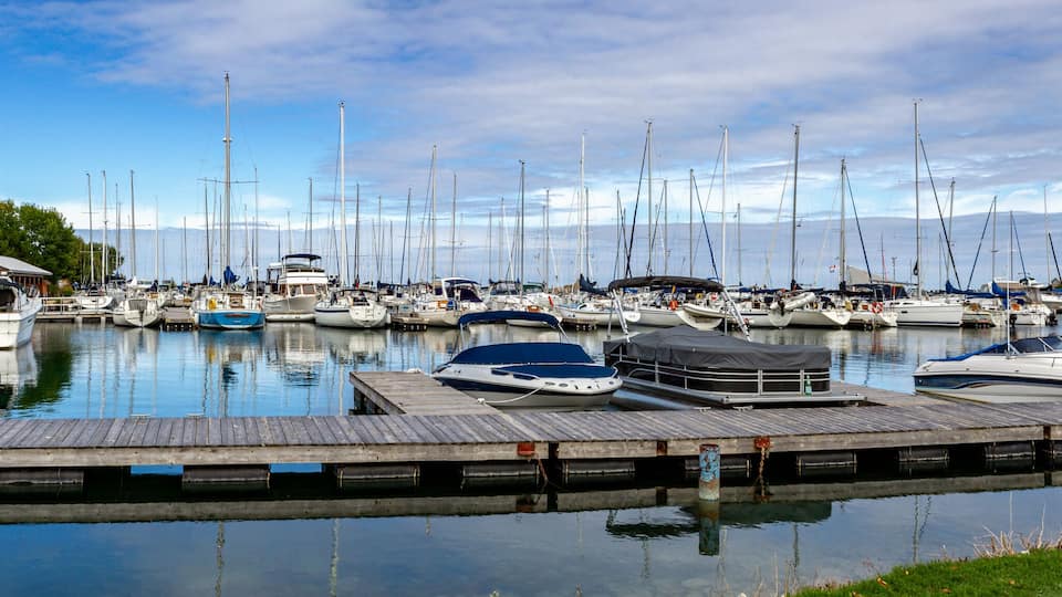 A marina with numerous sailboats docked at wooden piers.