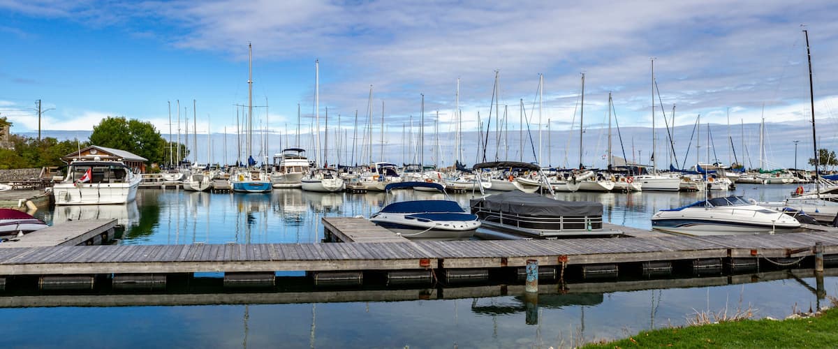 A marina with numerous sailboats docked at wooden piers.