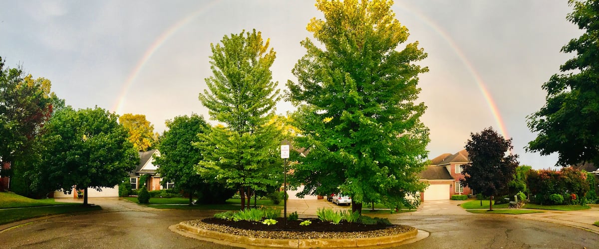 Scenic view of the perfect Semicircular rainbow after summer storm, over the sky of residential area in metro Detroit, Michigan