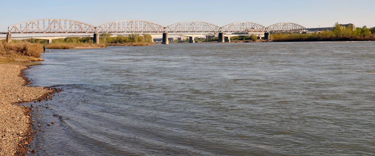 A river with a bridge in the background.