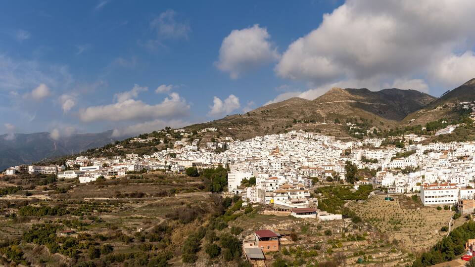 A mountainous town with white buildings and a clear blue sky.