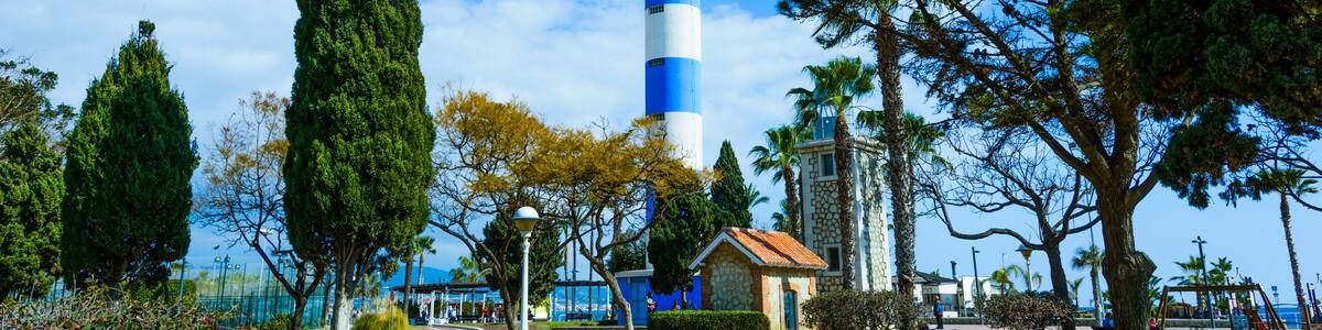 A lighthouse, a park with benches, and a clear blue sky.