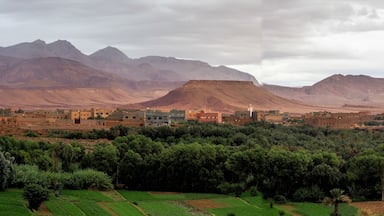 A town nestled in a valley with mountains in the background.