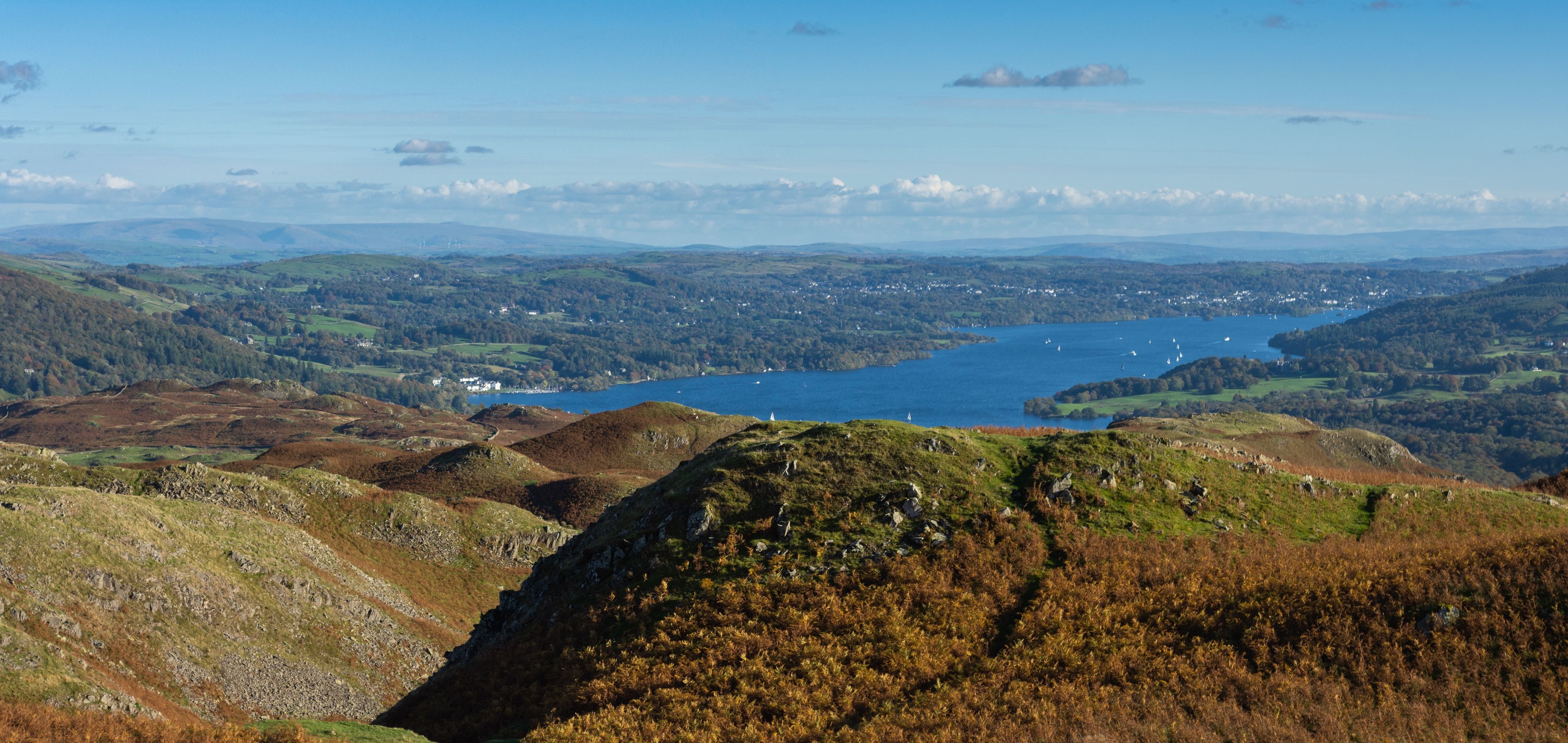 A mountainous landscape with a lake and scattered houses.