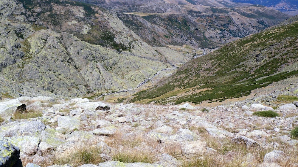 A rugged mountainous landscape with rocky terrain and sparse vegetation.