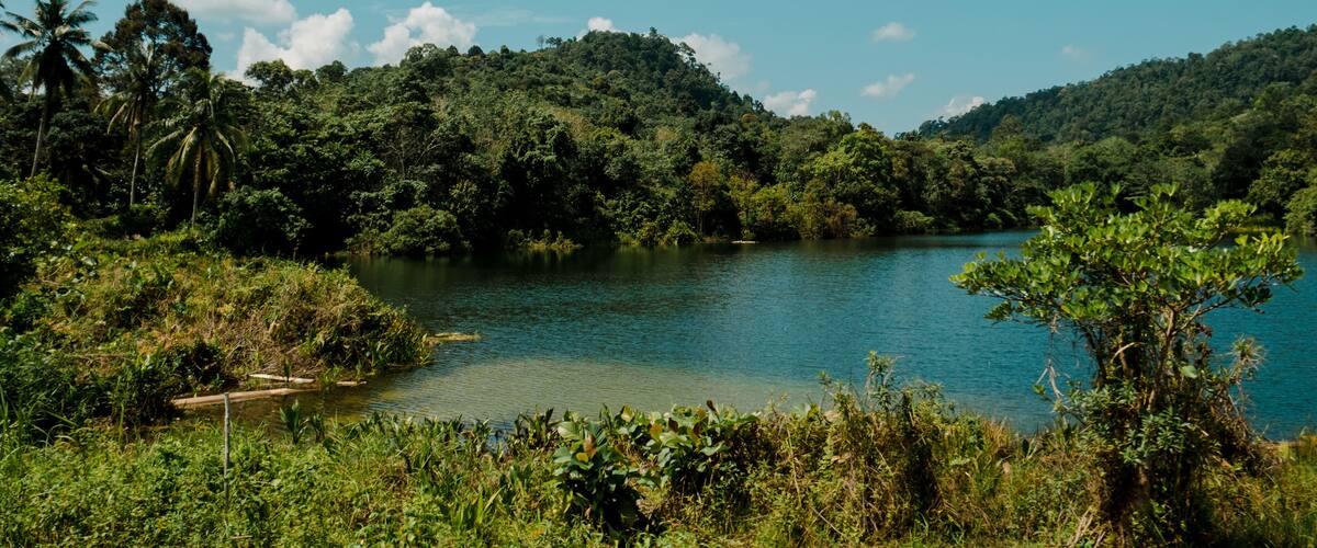 A serene lake surrounded by lush greenery and hills.