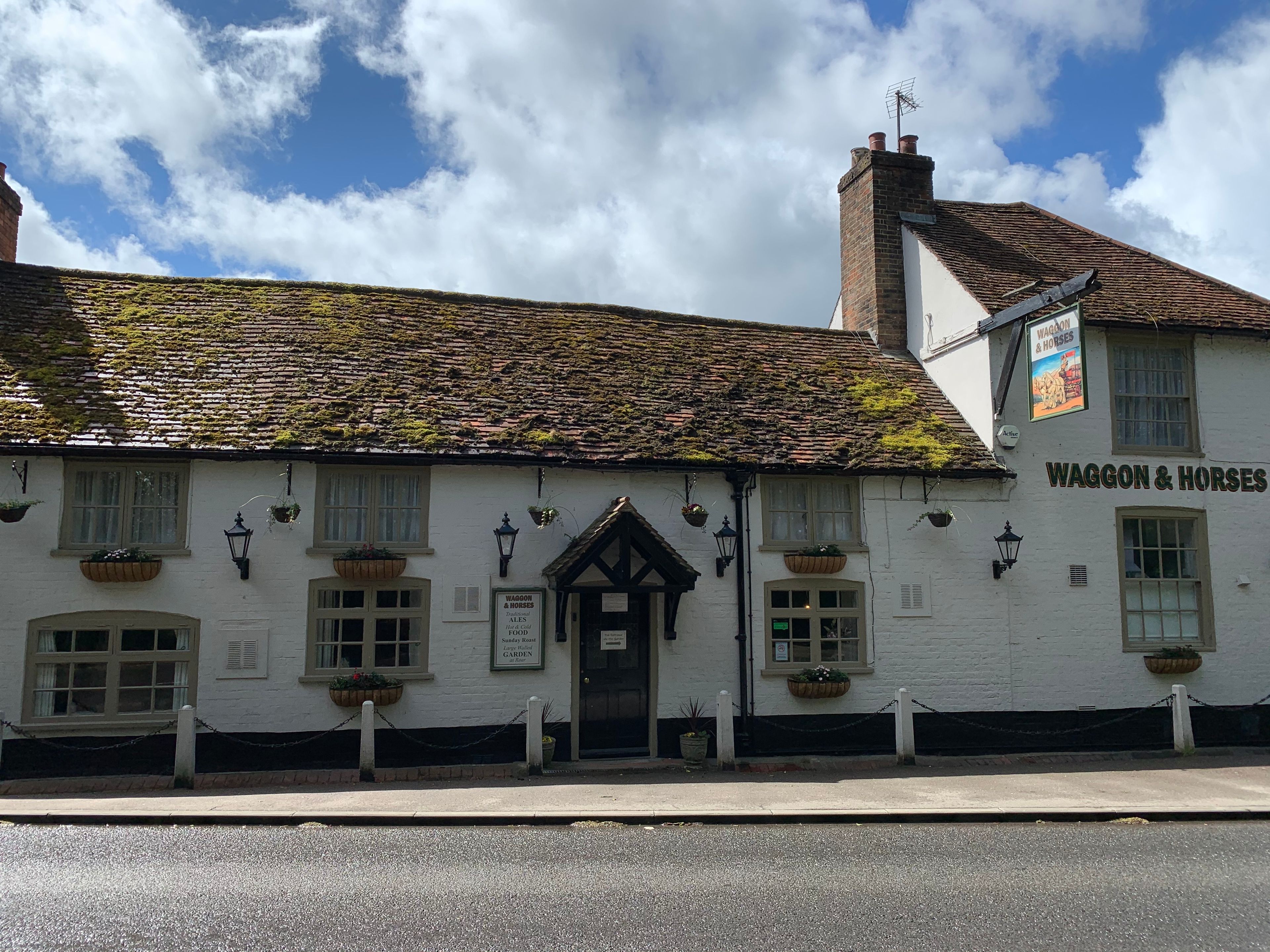 A traditional white building with a sign reading 'Waggon & Horses' and a rustic tiled roof.