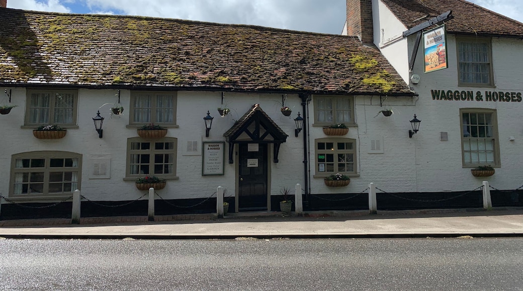 A traditional white building with a sign reading 'Waggon & Horses' and a rustic tiled roof.