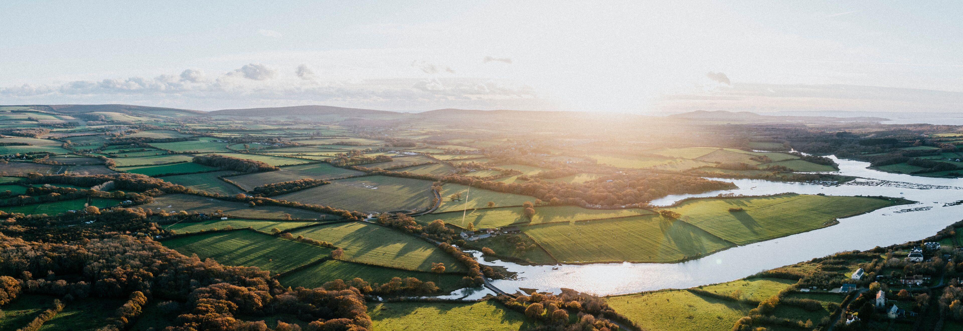 A river winding through terraced fields and rolling hills.