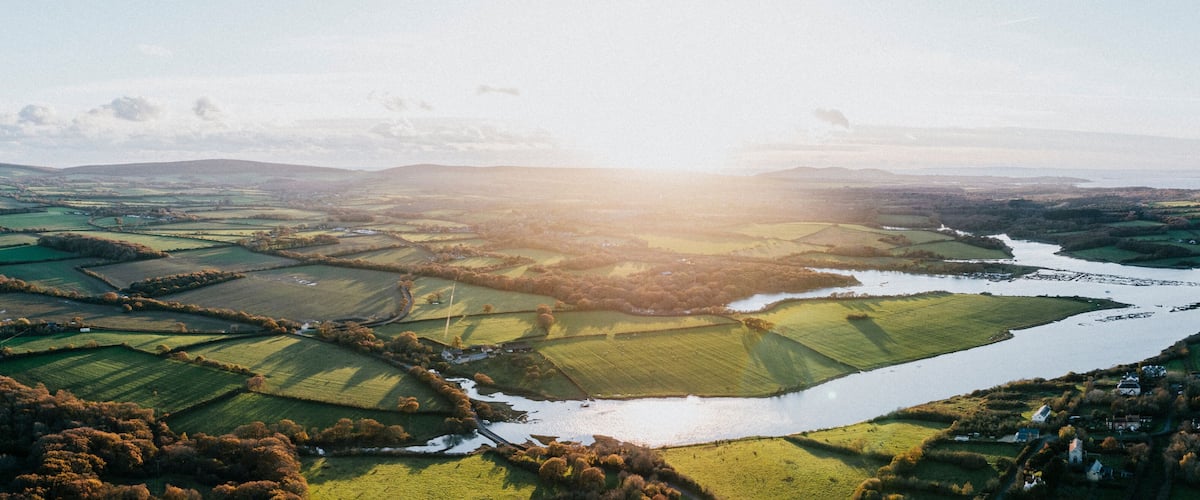A river winding through terraced fields and rolling hills.