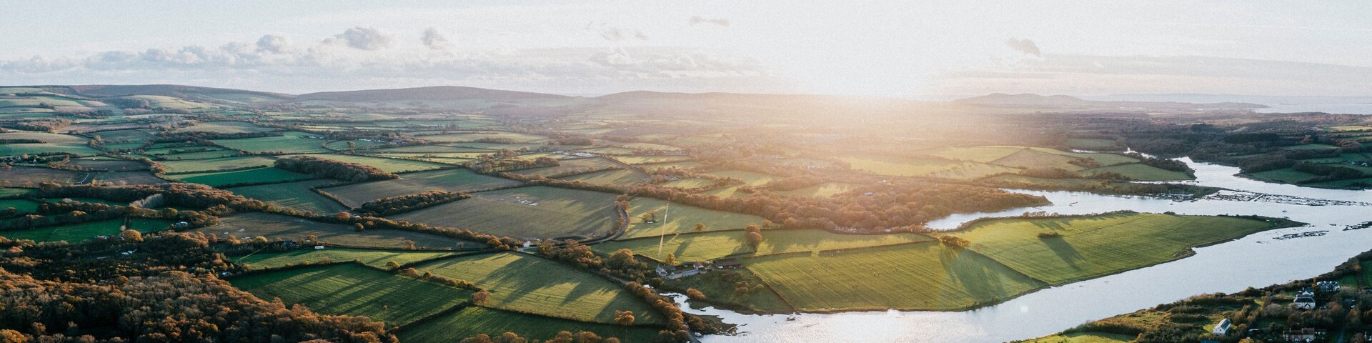 A river winding through terraced fields and rolling hills.