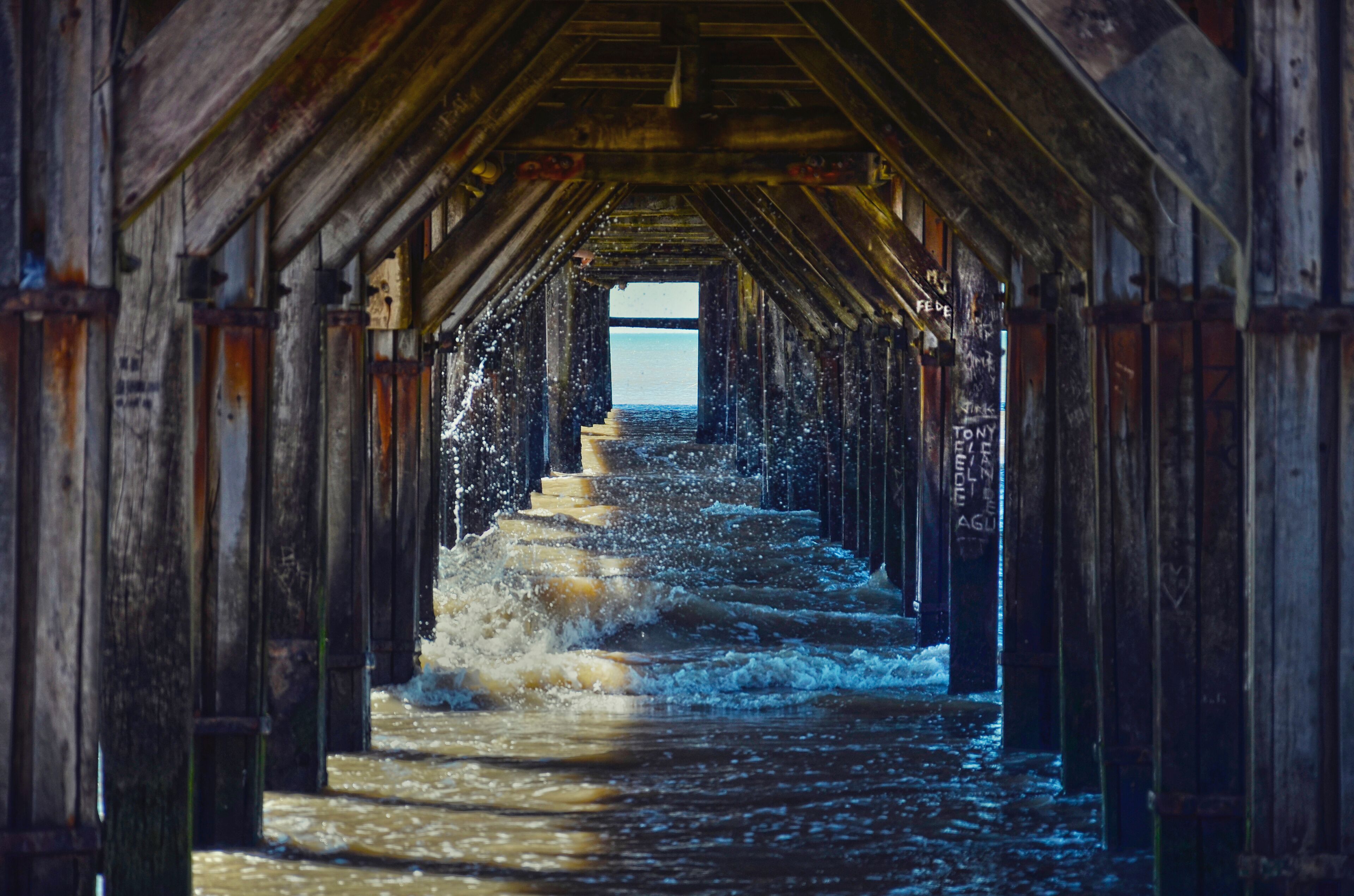 A wooden pier with water flowing over steps.