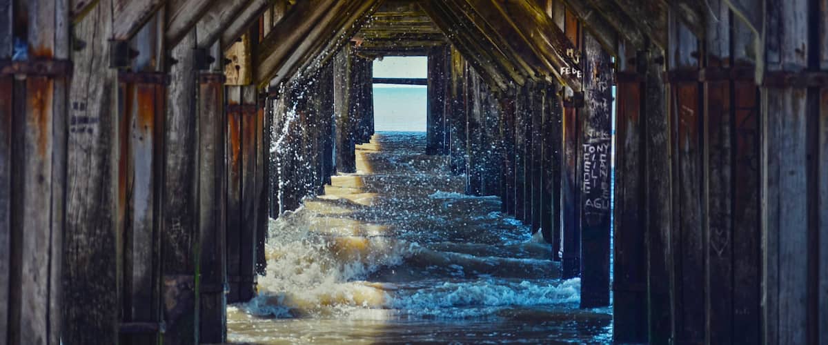 A wooden pier with water flowing over steps.