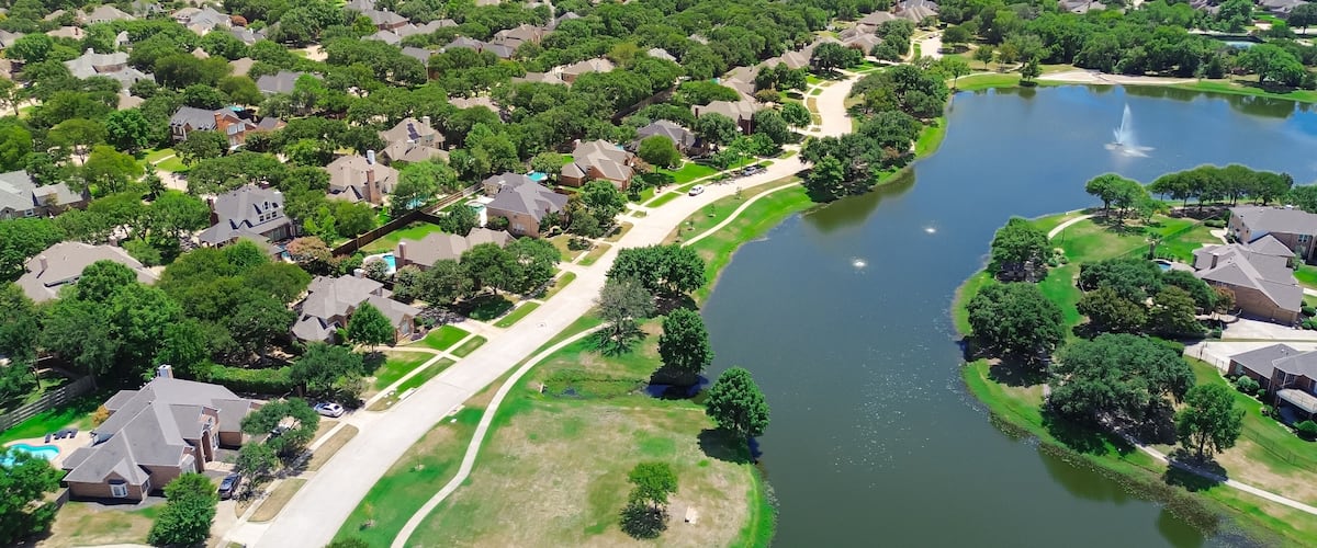 Neighborhood pond park with walking pathway trail in upscale lakeside residential area, two-story new development houses, urban forest mature trees, Keller, Tarrant County, suburbs Dallas, aerial