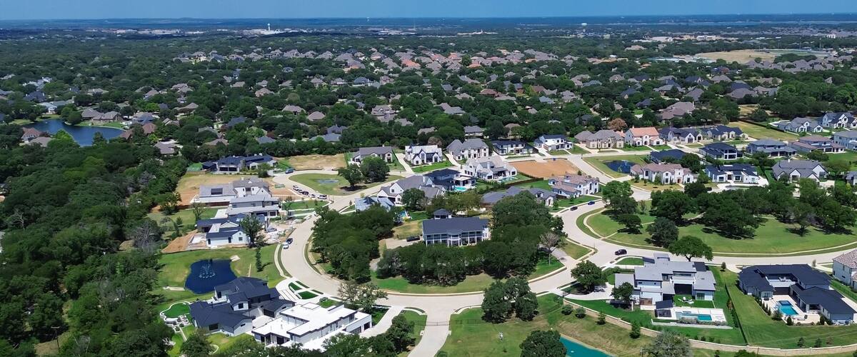 A suburban neighborhood with houses, roads, and a large body of water.
