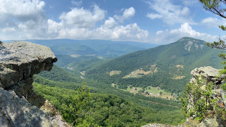 A mountainous landscape with rocky outcrops and dense forest.