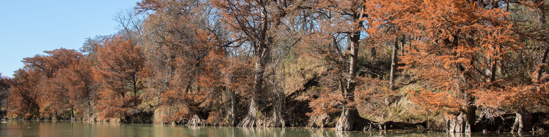 Un lago tranquilo rodeado de árboles de colores otoñales.