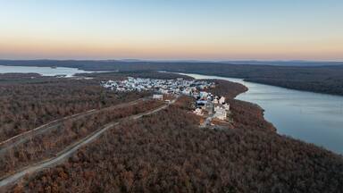 Panoramic view of lakeside houses and homes in Carlton Landing, Oklahoma resort town on Eufaula Lake during sunset with surrounding landscape