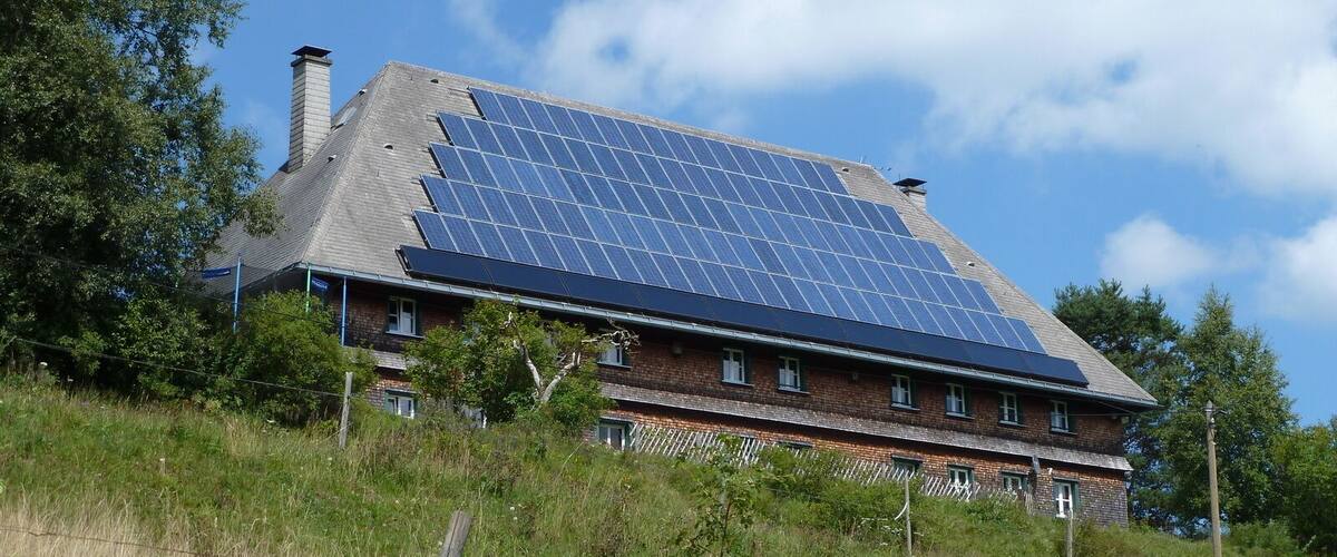 A house with a sloped roof and solar panels.