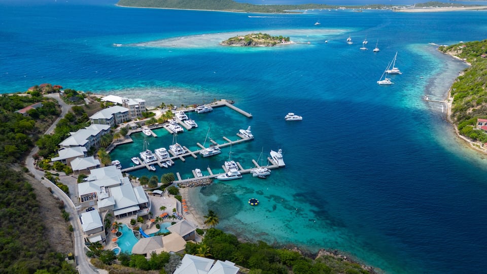 A marina with boats, a swimming pool, and a lush green landscape.