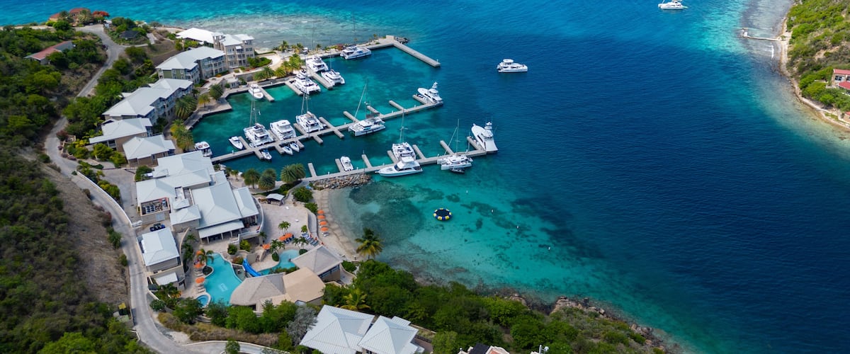 A marina with boats, a swimming pool, and a lush green landscape.