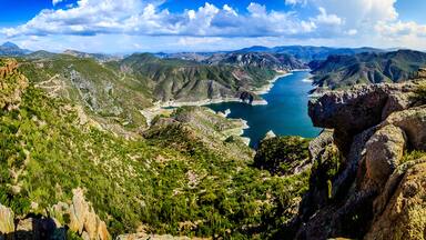 horizontal panoramic of lake in middle of the valley surrounded of mountains with green hills in sky with clouds in zimapan hidalgo