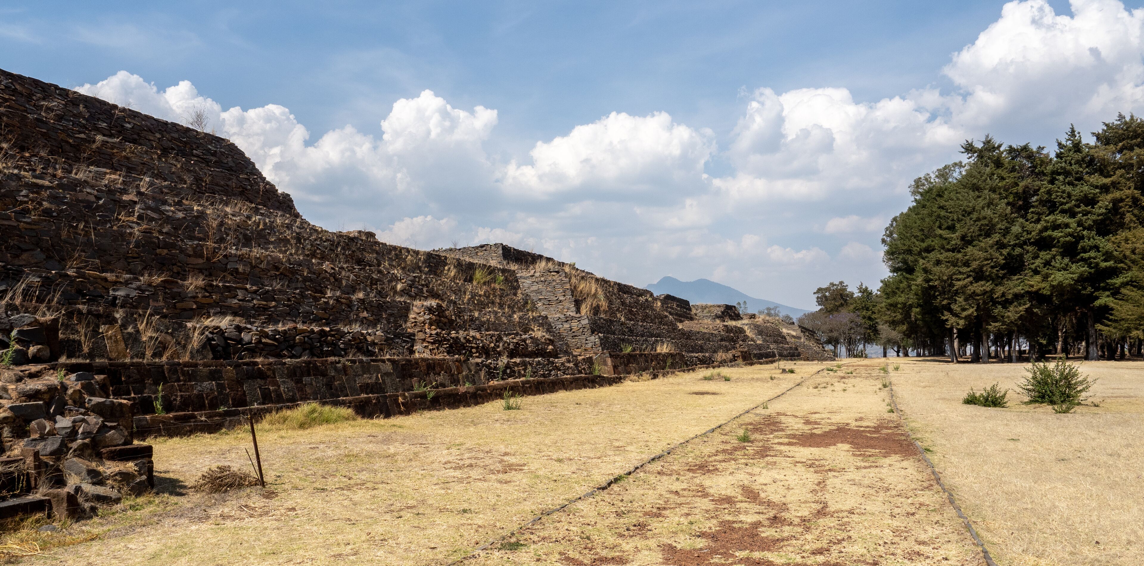 Ancient stone ruins with a clear sky and distant mountains.