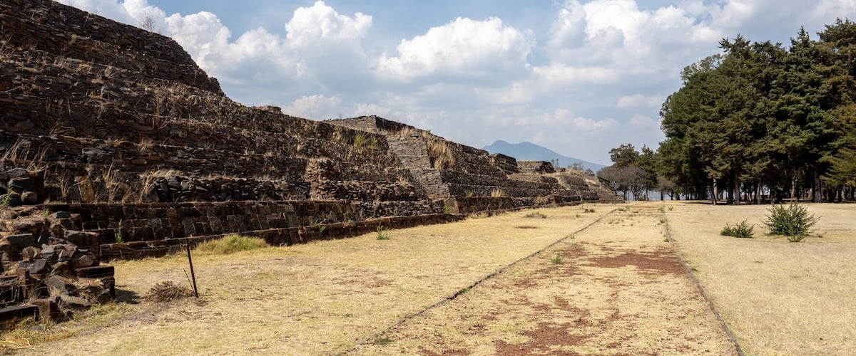 Ancient stone ruins with a clear sky and distant mountains.