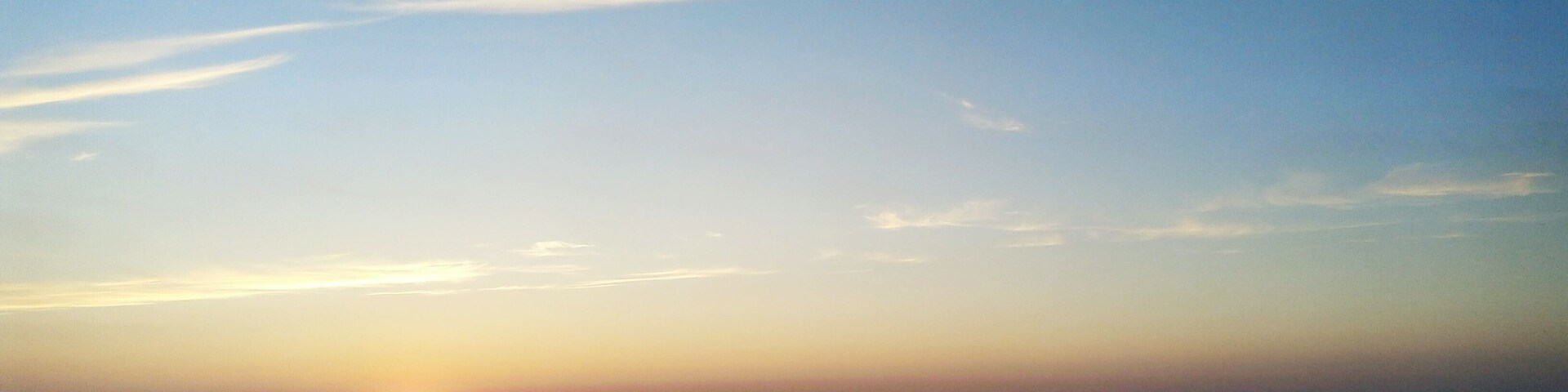 Un atardecer sobre un mar tranquilo con cielo despejado.