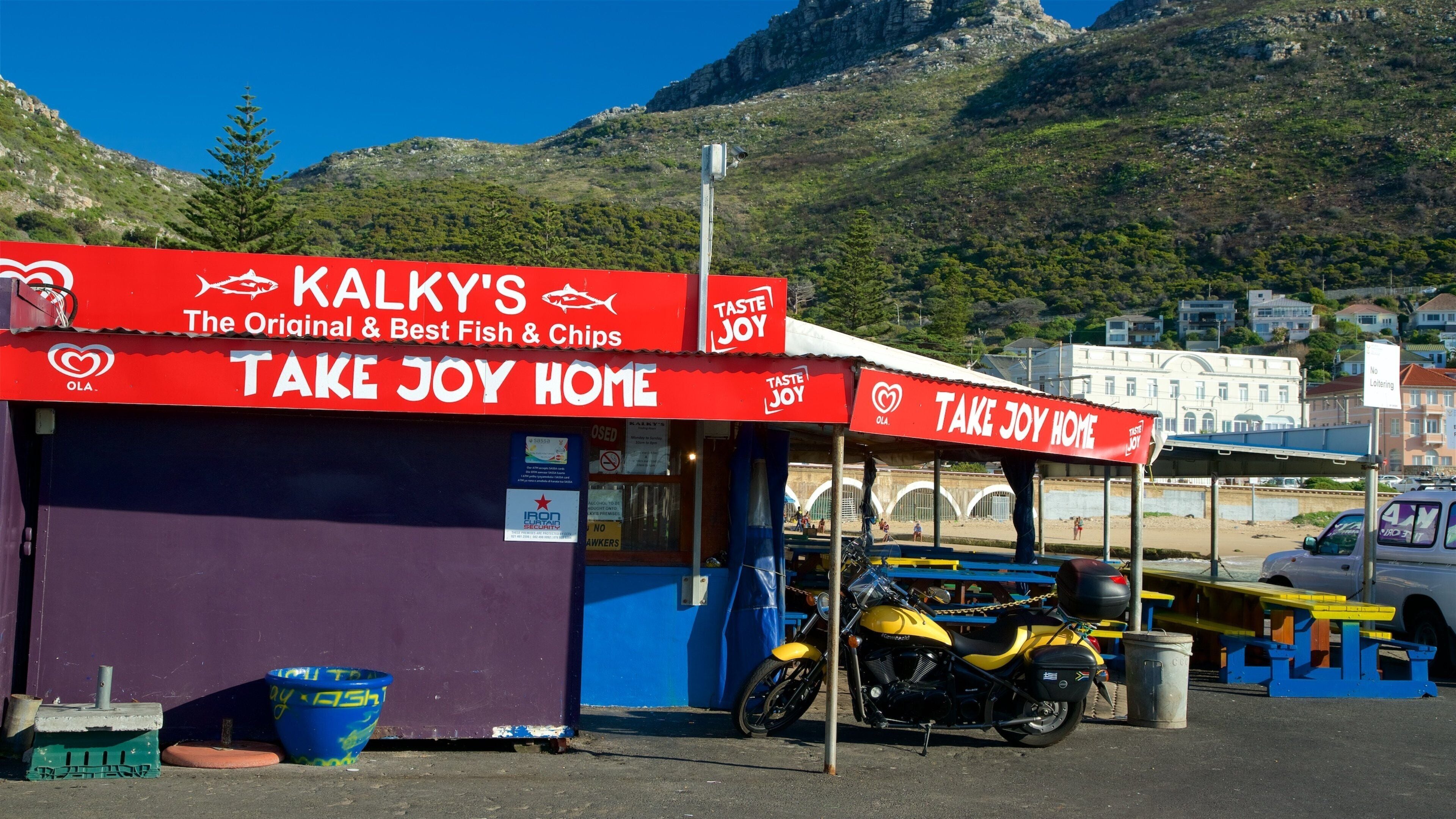Kalk Bay som omfatter skiltning, udendørs spisning og en strandbar