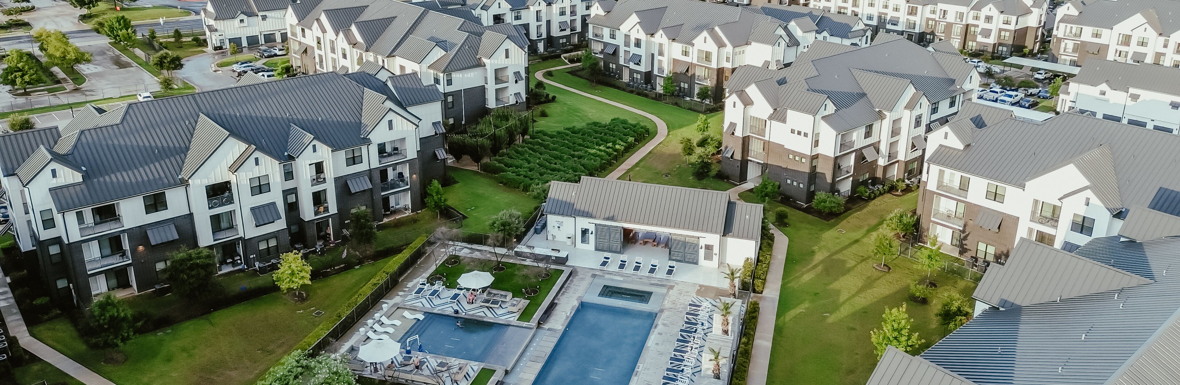 A residential area with modern houses, a swimming pool, and well-maintained lawns.