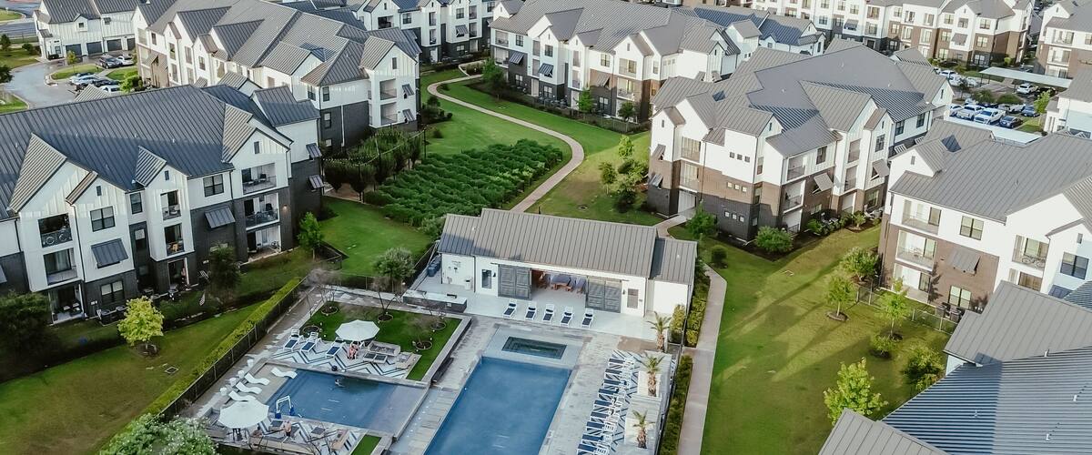 A residential area with modern houses, a swimming pool, and well-maintained lawns.