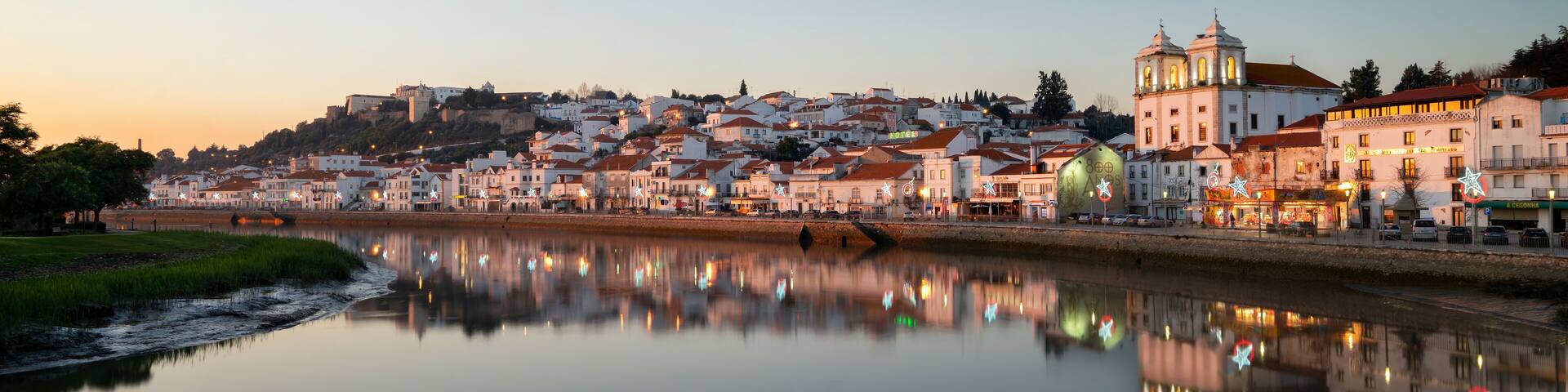 Panorama view of Alcacer do Sal cityscape from the other side of the Sado river at sunset