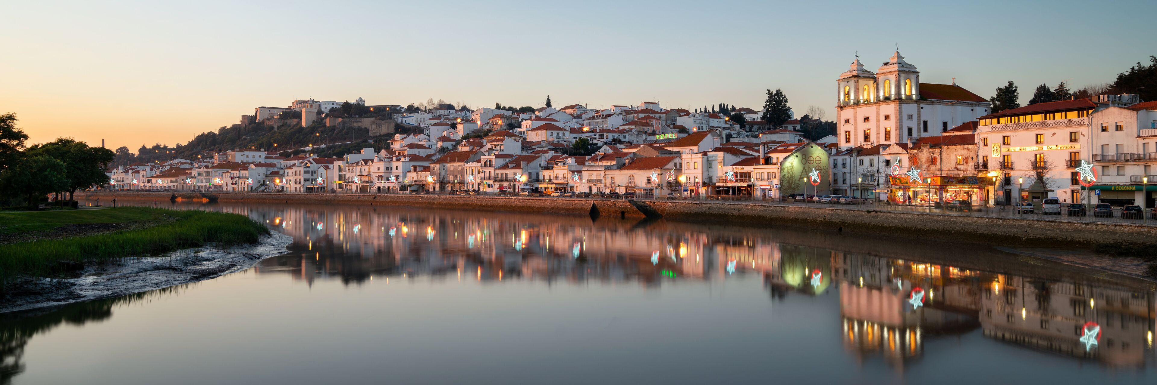 A riverside town with historic buildings and a prominent church.