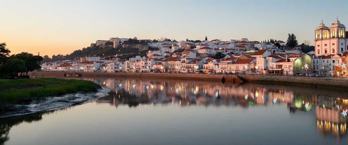 A riverside town with historic buildings and a prominent church.