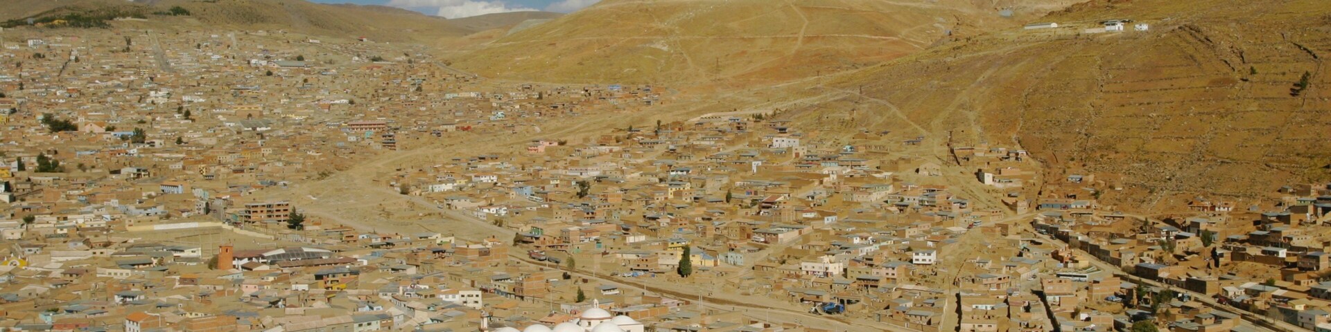 Un paisaje urbano con una montaña destacada al fondo.