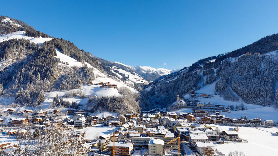 A snow-covered mountain village with buildings and a church.