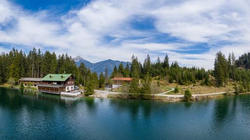 Panorama of Lake Frauensee with house at shore and blue cloudy sky in the spring