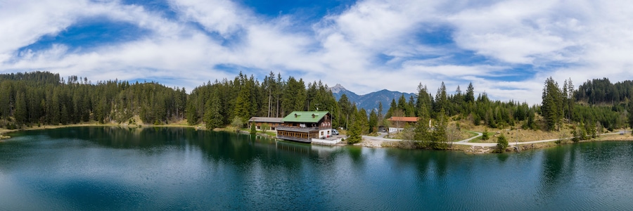 Panorama of Lake Frauensee with house at shore and blue cloudy sky in the spring