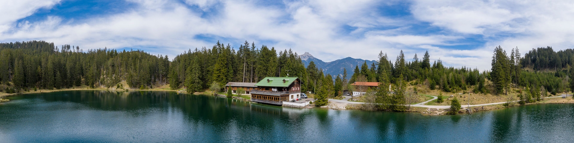 Panorama of Lake Frauensee with house at shore and blue cloudy sky in the spring