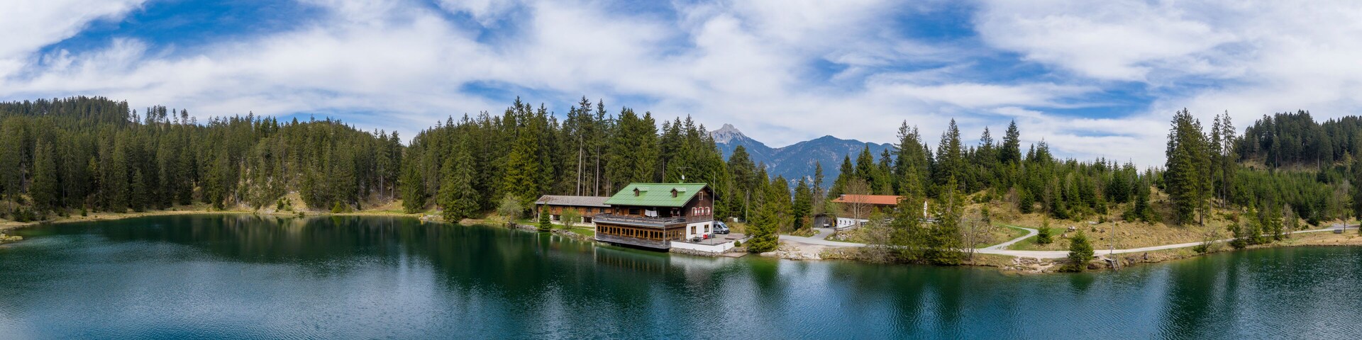 A lake surrounded by dense forest and mountains.