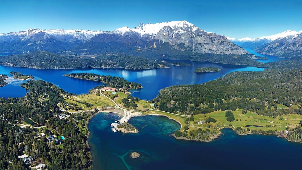 Un paysage montagneux parsemé de nombreux lacs et recouvert d’une forêt dense.