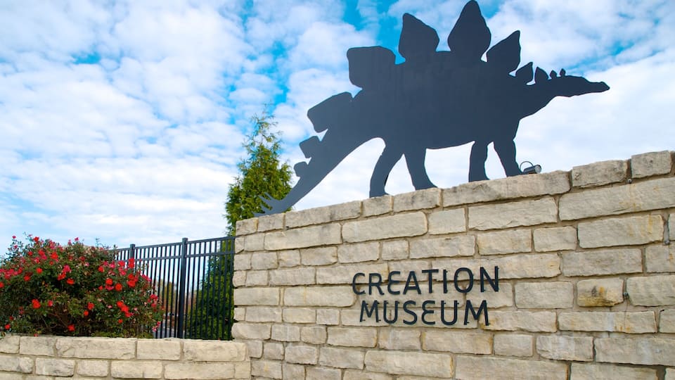 A stone wall with a dinosaur silhouette and the words "CREATION MUSEUM" on it.
