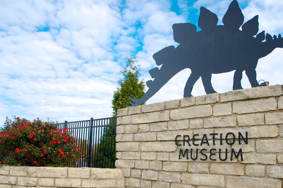 A stone wall with a dinosaur silhouette and the words "CREATION MUSEUM" on it.
